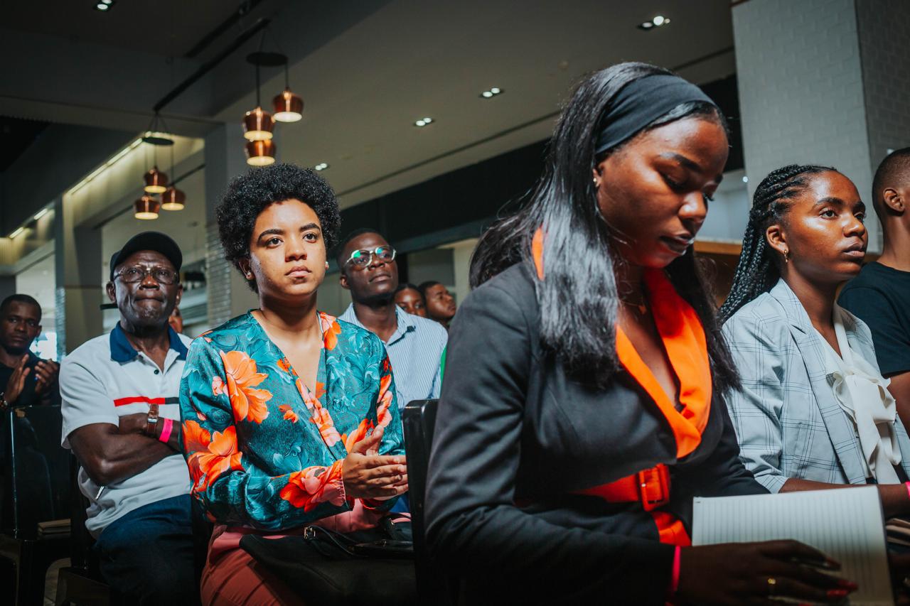 Mulher sorrindo em um evento da Web Summit, com um microfone.